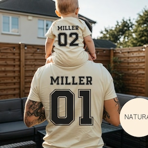 May include: Matching beige t-shirts with black lettering and numbers. The adult shirt reads "MILLER 01", while the child's shirt says "MILLER 02". The shirts are a light beige color, with a "NATURAL" circle in the bottom right corner.