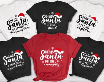 May include: A collection of Christmas-themed t-shirts in white, black, and red. Each shirt features the phrase "Dear Santa" with a Santa hat and a unique message, such as "It's actually a funny story" or "Define naughty."