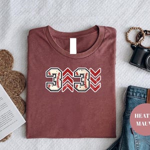 Baseball graphic shirt featuring the phrase 3 Up 3 Down displayed in bold distressed numbers with directional arrow accents; athletic-inspired typography arranged in a centered layout that reflects classic baseball scoreboard style; clean sports design created for fans players and game day wear