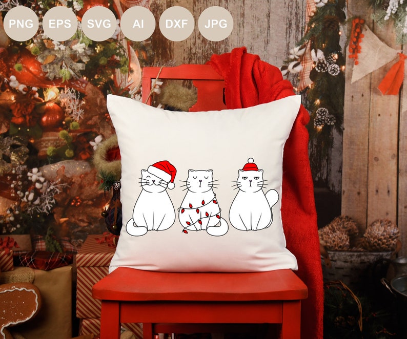 May include: White throw pillow with three white cats wearing Santa hats and Christmas lights. The cats are in a row, with the cat on the left wearing a Santa hat, the cat in the middle wearing Christmas lights, and the cat on the right wearing a Santa hat.
