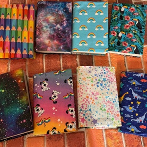 May include: Ten different book covers with various designs. The covers feature a rainbow of colours, stars, dinosaurs, and more.