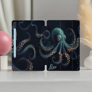 Könnte beinhalten: Eine schwarze und blaue Handyhülle mit einer Grafik eines Kraken und dem Namen "Alex" unten.