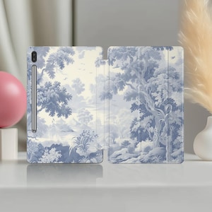 Peut inclure: Une coque de tablette avec un motif toile de Jouy bleu et blanc représentant un paysage avec des arbres, de l'eau et des oiseaux. L'étui est ouvert, révélant l'écran de la tablette et un stylet. L'ensemble est classique et élégant.