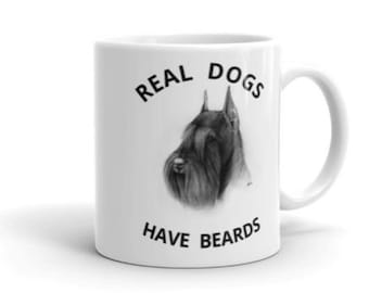 May include: White ceramic coffee mug with a black and white illustration of a dog with the text "REAL DOGS HAVE BEARDS".