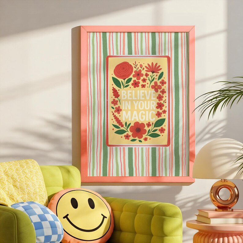 May include: A framed wall art print featuring a yellow rectangular center with red flowers and green leaves surrounding the text BELIEVE IN YOUR MAGIC. The background of the print has vertical stripes in shades of green, pink, and white.