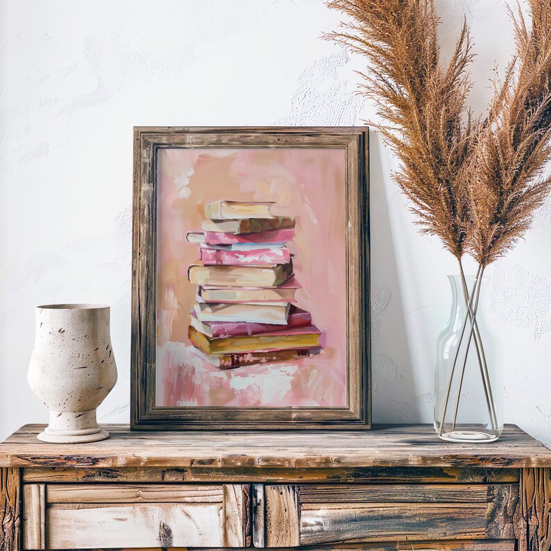 May include: A framed painting of a stack of books on a pink background. The books are various colors and sizes, and the painting is in a rustic wooden frame.