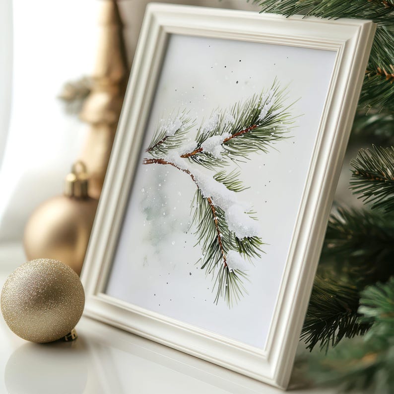 May include: A white frame with a watercolor painting of a pine branch covered in snow. The background is a light blue with white dots.