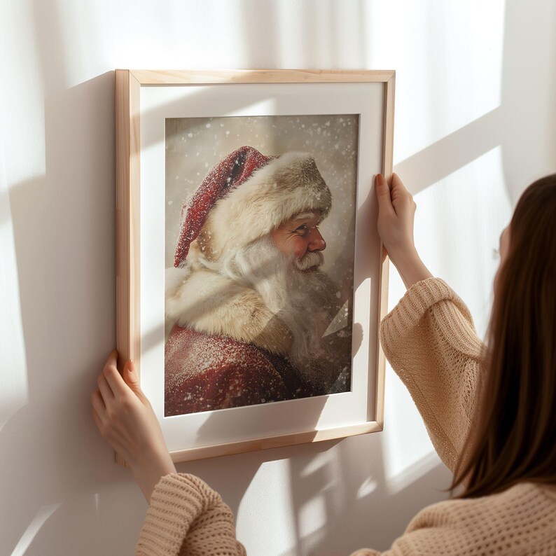Peut inclure: Une impression encadr&eacute;e d'un portrait de P&egrave;re No&euml;l. L'image montre le visage et les &eacute;paules du P&egrave;re No&euml;l, avec un chapeau rouge et blanc et une barbe blanche. L'arri&egrave;re-plan est une sc&egrave;ne enneig&eacute;e.