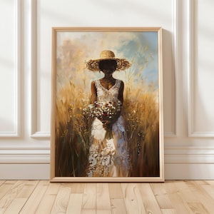 May include: A framed art print depicting a woman in a white dress and straw hat, holding flowers. The painting is set in a field of tall grass, with a soft, painterly style. The frame is made of light-coloured wood.