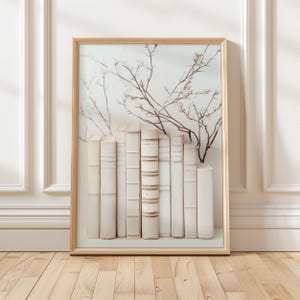 May include: A framed print of a white bookshelf with a row of antique books and a delicate floral arrangement in the background.
