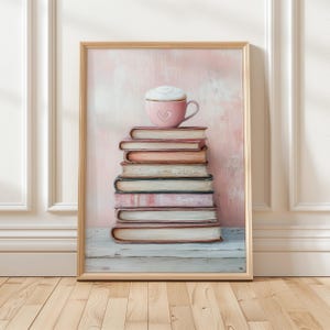 Könnte beinhalten: Eine rosa Kaffeetasse mit einem Herzdesign steht auf einem Stapel antiker Bücher vor einem hellrosa Hintergrund. Die Bücher sind ordentlich gestapelt, die Tasse ruht auf dem obersten Buch. Das Bild hat eine sanfte, romantische Atmosphäre.