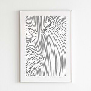 K&ouml;nnte beinhalten: Schwarz-wei&szlig;es abstraktes Linienkunst-Druckbild in einem silbernen Rahmen. Die Linien sind geschwungen und erzeugen ein wirbelndes Muster.