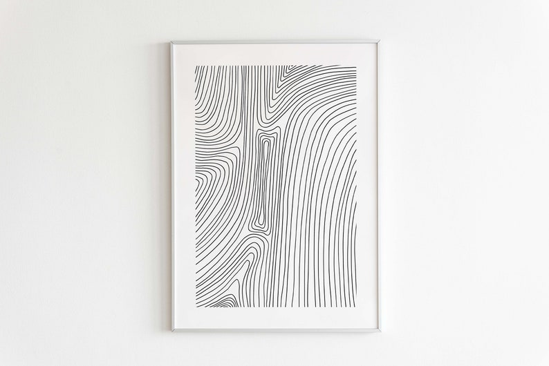 K&ouml;nnte beinhalten: Schwarz-wei&szlig;es abstraktes Linienkunst-Druckbild in einem silbernen Rahmen. Die Linien sind geschwungen und erzeugen ein wirbelndes Muster.