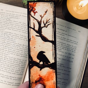 May include: A black crow perched on a branch of a tree with orange and red watercolor accents. The background is a light beige with a black border. The text "Chapter IV" is visible in the upper right corner.
