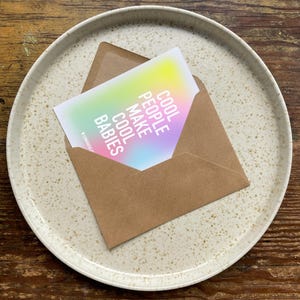 May include: A card with a rainbow gradient background and the text "Cool People Make Cool Babies" in white.