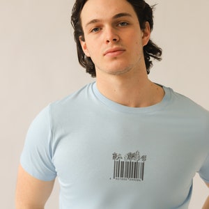 May include: A light blue t-shirt with a black and white barcode graphic of trees. The barcode reads "4 907000 099086".