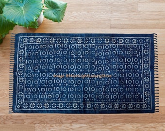 May include: A blue and white cotton rug with a geometric pattern. The rug has a fringe border and is made in India.