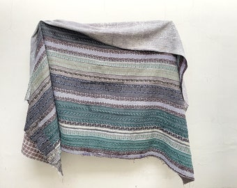 May include: A striped kantha quilt with a variety of colors, including green, blue, brown, and white. The quilt is made of cotton and has a hand-stitched design.