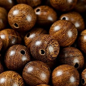 以下が含まれることがあります： 濃い茶色の木製ビーズが詰まったボウル。ビーズは滑らかで、自然な木目模様があります。