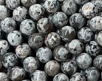 Op de afbeelding: Een streng ronde, zwart-wit gespikkelde kralen. De kralen zijn ongeveer 8 mm in diameter en hebben een gladde, gepolijste afwerking.