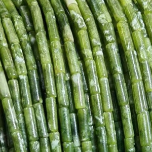 Może przedstawiać: Szereg zielonych koralików z jadeitu, każdy koralik to cylinder z zielono-białym wzorem.