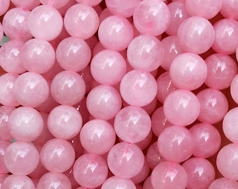 May include: A strand of pink rose quartz beads. The beads are round and smooth, and they are strung on a clear elastic cord. The beads are approximately 6mm in diameter.