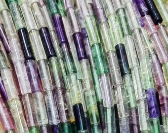 May include: A strand of multi-colored fluorite beads. The beads are cylindrical and have a translucent, iridescent appearance. The colors include green, purple, and white.