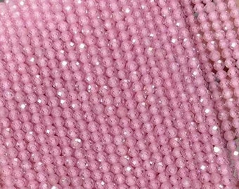 May include: A strand of pink faceted beads. The beads are small and round, and they have a sparkly finish.