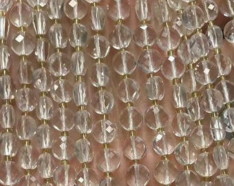 May include: Strands of clear, faceted crystal beads. The beads are strung together with gold-colored wire, creating a shimmering effect. The beads are round and oval-shaped, reflecting light. The overall theme is jewelry making and crafting.