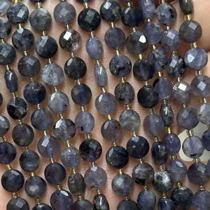 Peut inclure: Un brin de perles de pierres précieuses facettées bleu foncé. Les perles sont rondes et ont une forme légèrement irrégulière. Les perles sont enfilées sur un fil transparent.