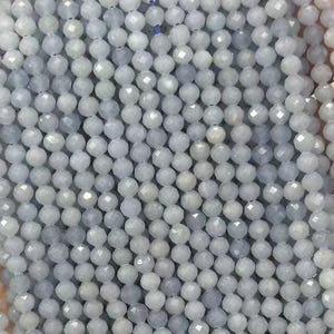 May include: A collection of light blue faceted beads strung together. The beads are small and round, with a slightly iridescent quality. The beads are a pale, cool blue colour, and appear to be made of glass or a similar material. The beads are strung on a thin, clear cord.
