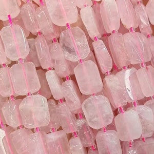 Könnte beinhalten: Eine Strähne aus rosafarbenen Rosenquarzperlen, jede Perle ist facettiert und hat eine rechteckige Form. Die Perlen sind auf einer durchsichtigen Gummikordel aufgefädelt.