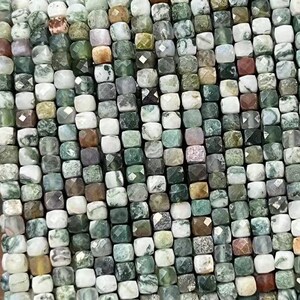 Puede incluir: Una hebra de cuentas cuadradas verdes, blancas y marrones hechas de ágata musgosa. Las cuentas miden aproximadamente 4 mm.