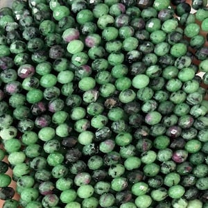 Może przedstawiać: Sznur zielonych koralików z kamieni szlachetnych o fasetowanym wykończeniu. Koraliki są małe i okrągłe, mają lekko nieregularny kształt. Koraliki są nawleczone na przezroczystą nić.