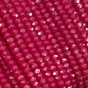 Puede incluir: Una hebra de cuentas de piedras preciosas facetadas de color rosa brillante. Las cuentas son pequeñas y redondas, y están enhebradas en un hilo transparente. Las cuentas están dispuestas en línea recta, y todas son del mismo tamaño y forma.