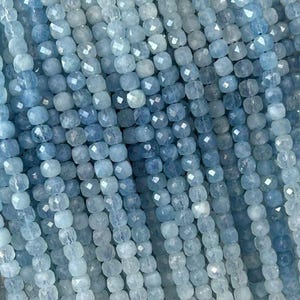 Puede incluir: Una hebra de cuentas de aguamarina azul claro, facetadas y redondas, con una ligera variación de color. Las cuentas están enhebradas en un hilo transparente y tienen aproximadamente 4 mm de diámetro.