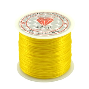 May include: A spool of bright yellow elastic string labeled "Strong & Stretchy" and "Crystal String".