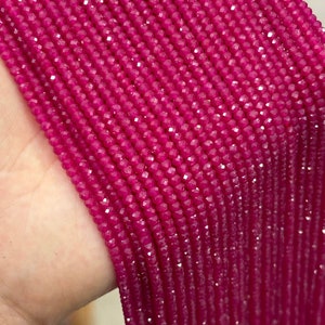 May include: A strand of bright pink faceted gemstone beads. The beads are small and uniform in size, creating a smooth and elegant look.