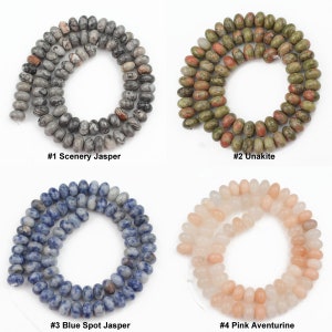K&ouml;nnte beinhalten: Vier Str&auml;nge aus Edelsteinperlen, jede mit einem anderen Muster und einer anderen Farbe. Die Perlen sind kreisf&ouml;rmig angeordnet, mit dem Text "#1 Scenery Jasper", "#2 Unakite", "#3 Blue Spot Jasper" und "#4 Pink Aventurine" unter jedem Strang.