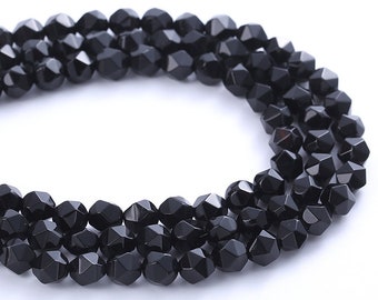 May include: A strand of black faceted gemstone beads. The beads are round and have a shiny finish.