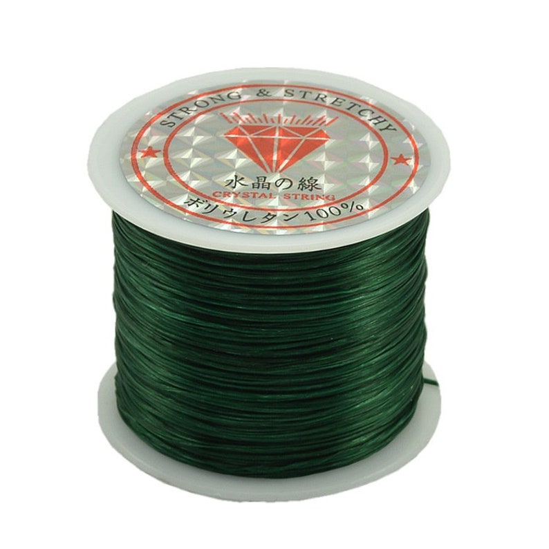 May include: A spool of dark green elastic string, labeled "Strong & Stretchy" and "Crystal String 100%" in Japanese and English.