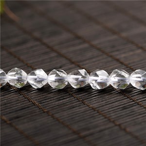 May include: A strand of clear faceted crystal beads. The beads are round and have a smooth, polished finish.