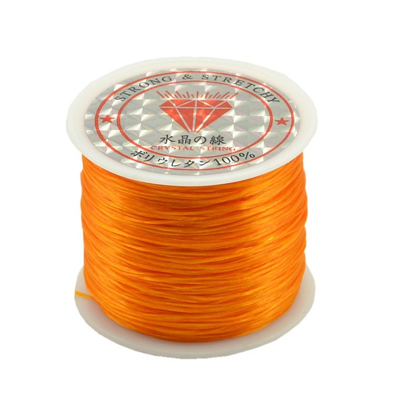 May include: A spool of orange elastic string labeled "Strong & Stretchy" and "Crystal String 100%".