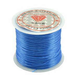 May include: A spool of blue elastic string for jewelry making. The label reads "Strong & Stretchy" and "Crystal String 100%".