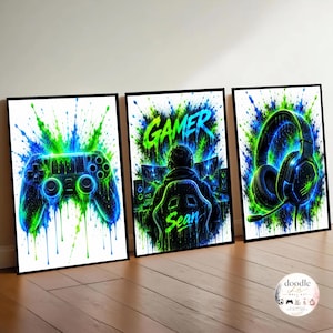 Op de afbeelding: Drie ingelijste wandposters met levendige blauwe en groene verfspatten. De linker poster toont een gamecontroller, de middelste een persoon achter een computer met de tekst GAMER Sean, en de rechter poster toont een headset.