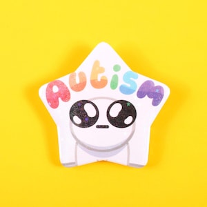 May include: A white star-shaped badge with the word "Autism" in rainbow colours. The badge features a cartoon character with large, black eyes and a small mouth. The background is a solid yellow.