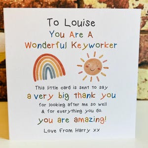 May include: A colourful card with a rainbow and sun illustration. The card says "To Louise You Are A Wonderful Keyworker This little card is sent to say a very big thank you for looking after me so well & for everything you do. you are amazing! Love From Harry xx"