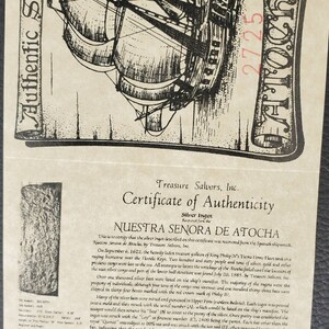 May include: A certificate of authenticity for a silver ingot recovered from the Nuestra Se&ntilde;ora de Atocha shipwreck. The certificate features a black and white illustration of the ship and includes the text "Nuestra Se&ntilde;ora de Atocha" and "Treasure Salvors, Inc."
