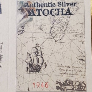 May include: A vintage map with a ship illustration and the text "Authentic Silver ATOCHA 1946" printed on it. The map shows the location of Madagascar and the Tropic of Capricorn.