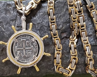 May include: A silver coin with a cross design is encased in a gold-toned pendant with a ship's wheel design. The pendant is attached to a two-tone silver and gold chain.